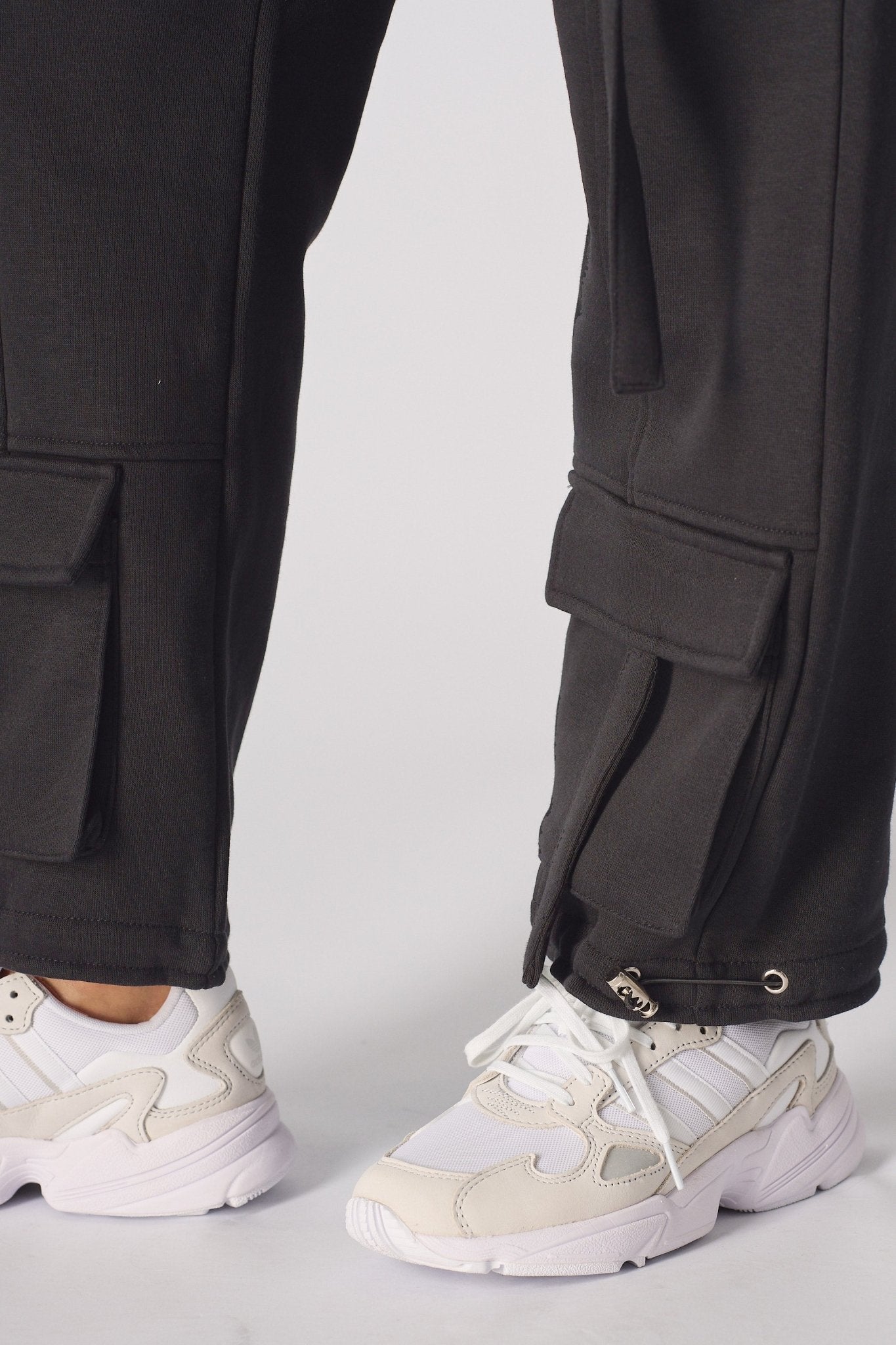 Detailed view of the comfortable drawstring waist on black cargo trousers.