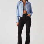 Model walking in women's high-waisted black bootcut jeans with white contrast stitching