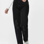 Person wearing black distressed jeans and white sneakers on a white background