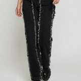 Person wearing black distressed jeans on a white background