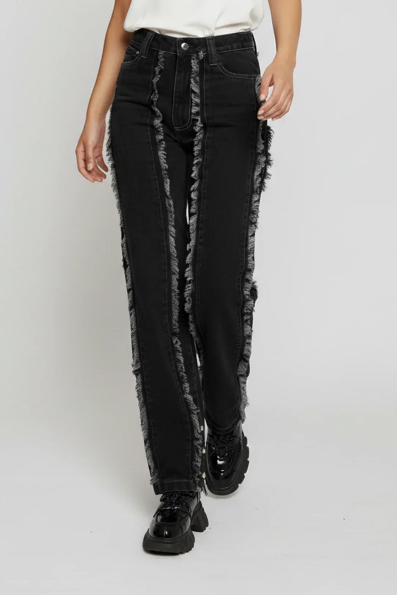 Person wearing black distressed jeans on a white background