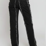 Person wearing black distressed jeans with gray trim on a white background