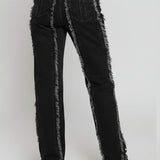 Person wearing black distressed jeans with gray trim on a white background
