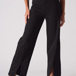 Studio shot of model wearing black wide leg jeans with embellished pockets