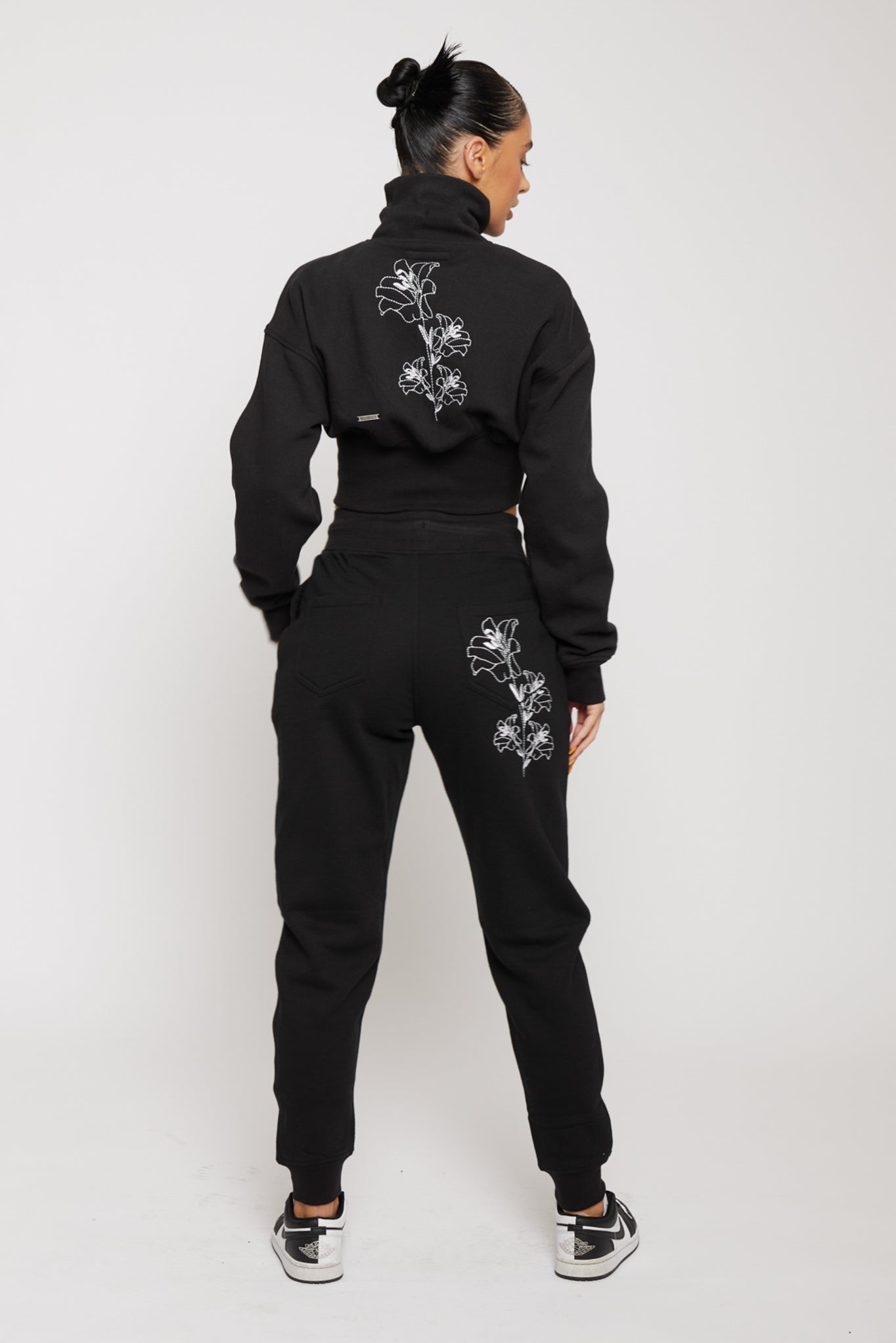 Full back view of the black joggers and hoodie set with matching floral embroidery