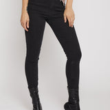 Person wearing black high-waisted jeans and black knee-high boots on a white background