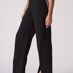 Close up of the button closure and belt loops on black high-waisted jeans