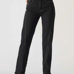 Person wearing black jeans on a plain background