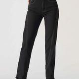 Person wearing black jeans on a plain background