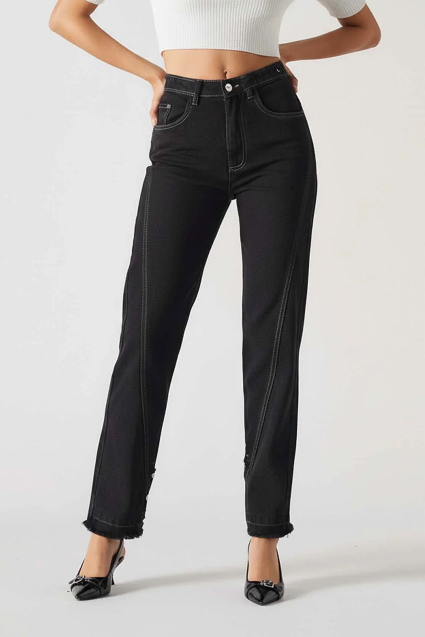 Person wearing black jeans on a plain background
