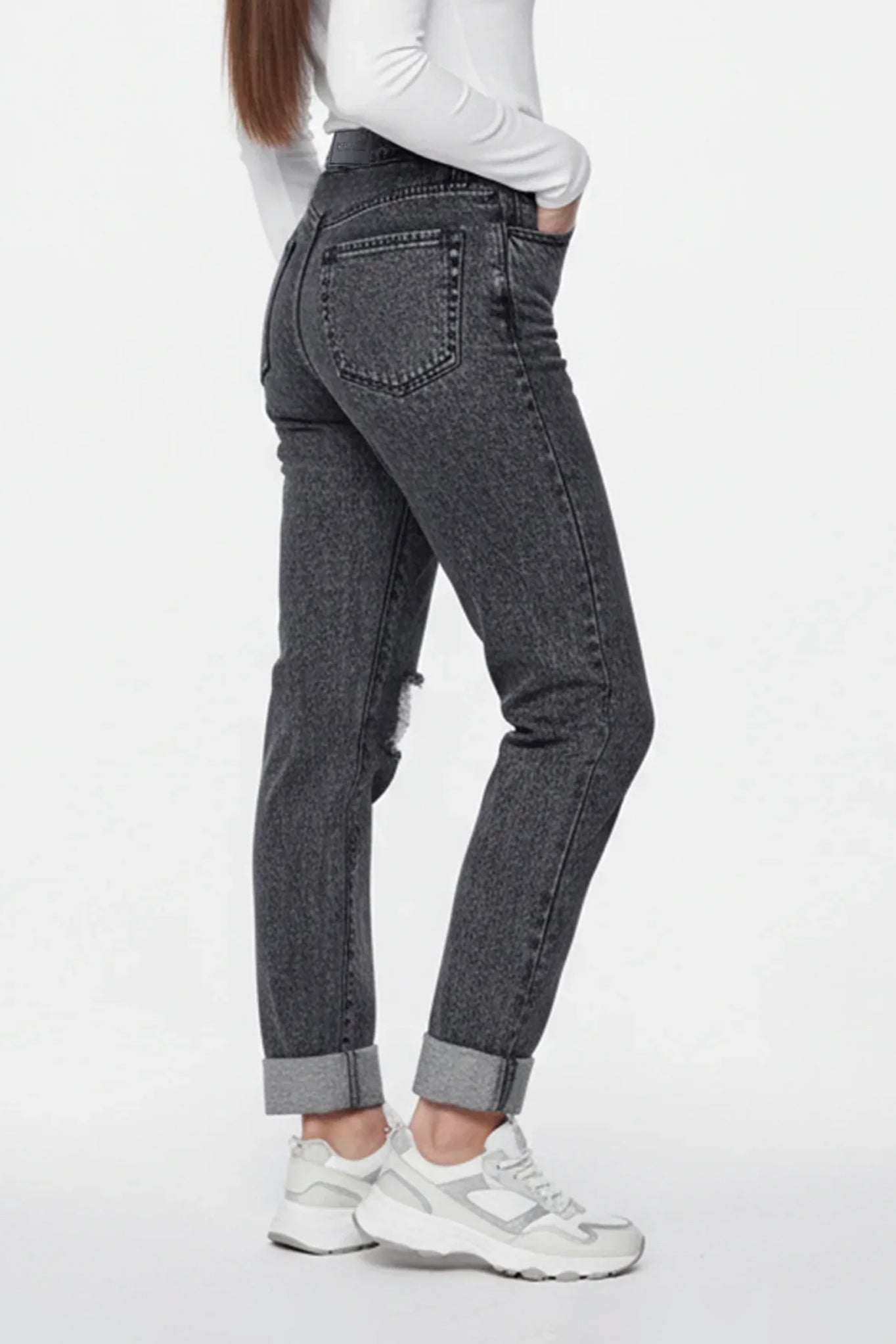 Person wearing black jeans with a white background