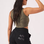 Close up side view of the tonal embroidered logo on black jogger shorts