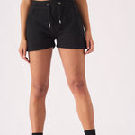 Full length front view of a woman in black jogger shorts and a green cap