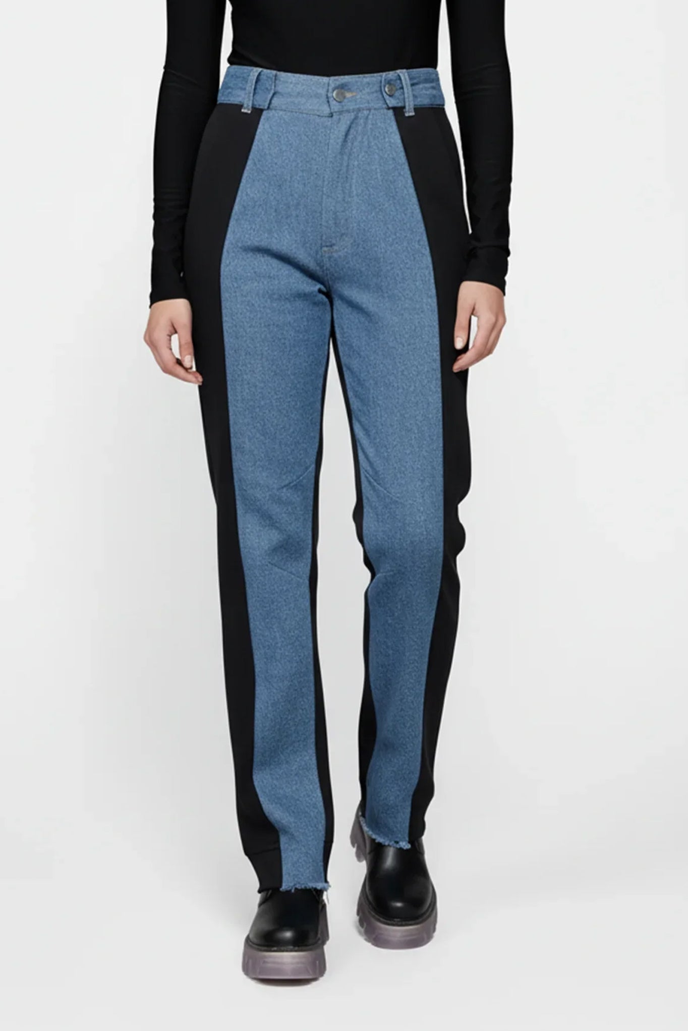 Person wearing black long-sleeve top and blue jeans on a white background