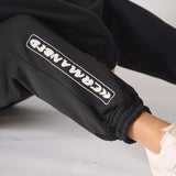 Close up showing the bold linear insignia on the black oversized joggers womens.