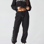 Full body front shot of a model wearing black oversized joggers womens and a sweatshirt.