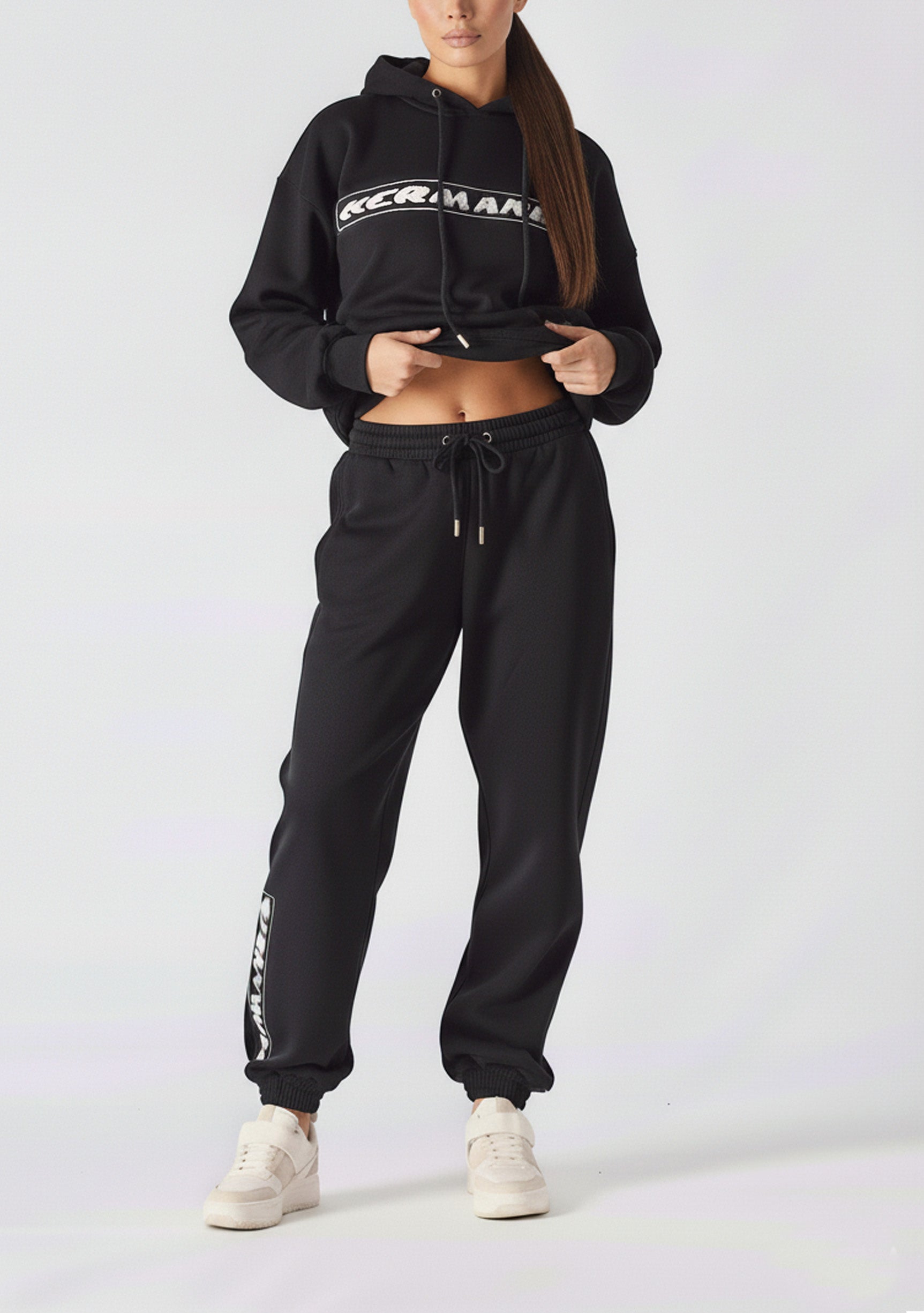 Full body front shot of a model wearing black oversized joggers womens and a sweatshirt.