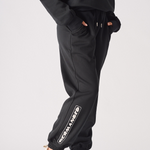 Side profile of a model posing in comfortable black oversized joggers womens.