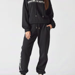 A woman standing in premium black oversized joggers womens for a casual look.