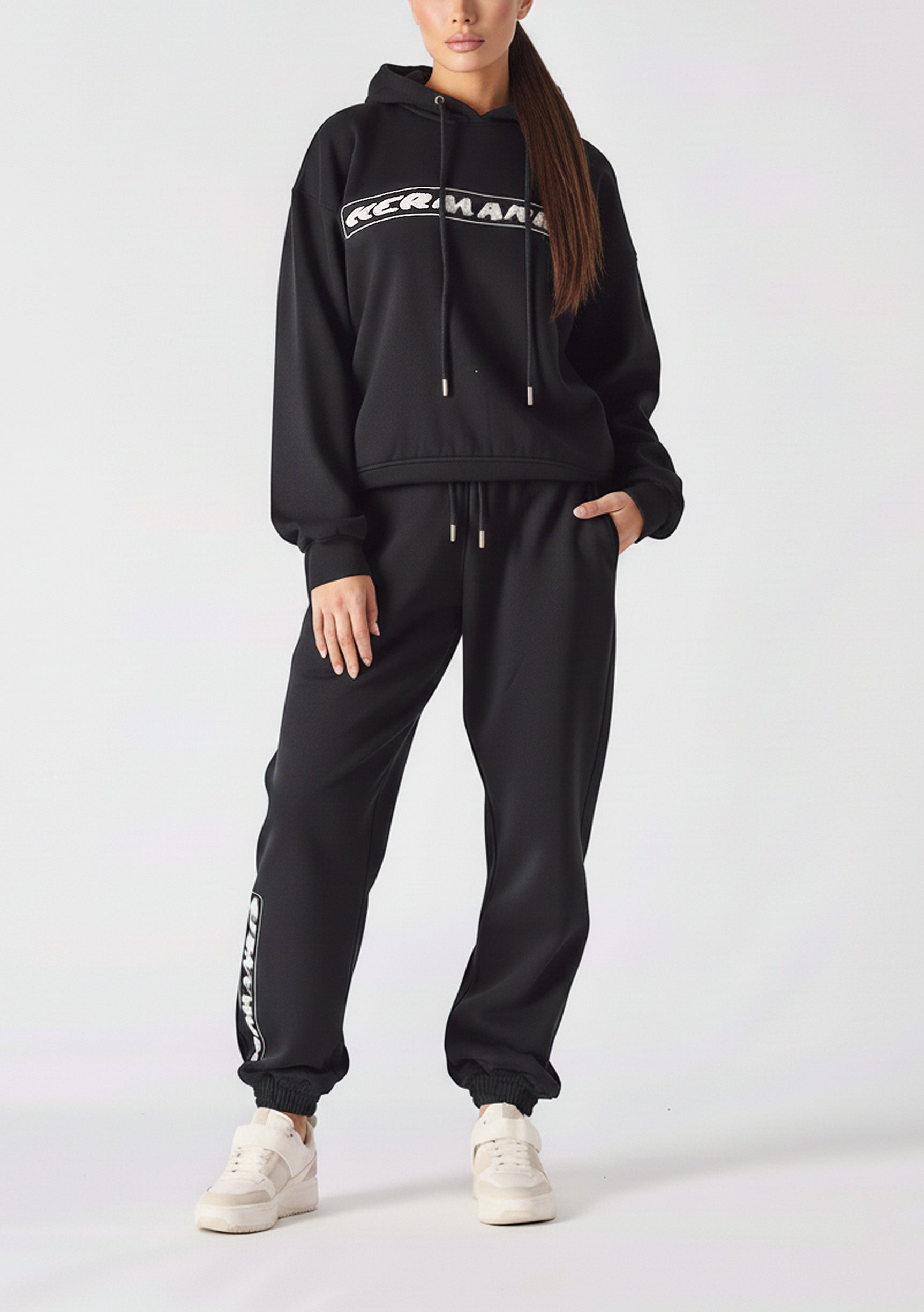 A woman standing in premium black oversized joggers womens for a casual look.