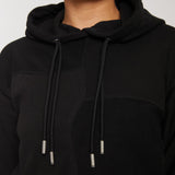 close up of metal tipped drawstrings on black hoodie