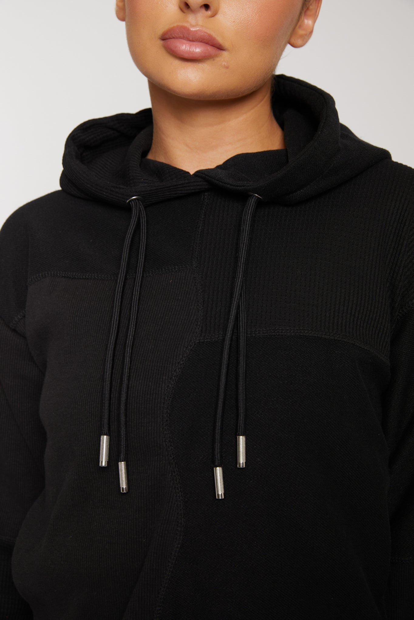 close up of metal tipped drawstrings on black hoodie