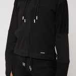 close up of metal plate detail on black hoodie hem