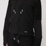 close up of metal plate detail on black hoodie hem