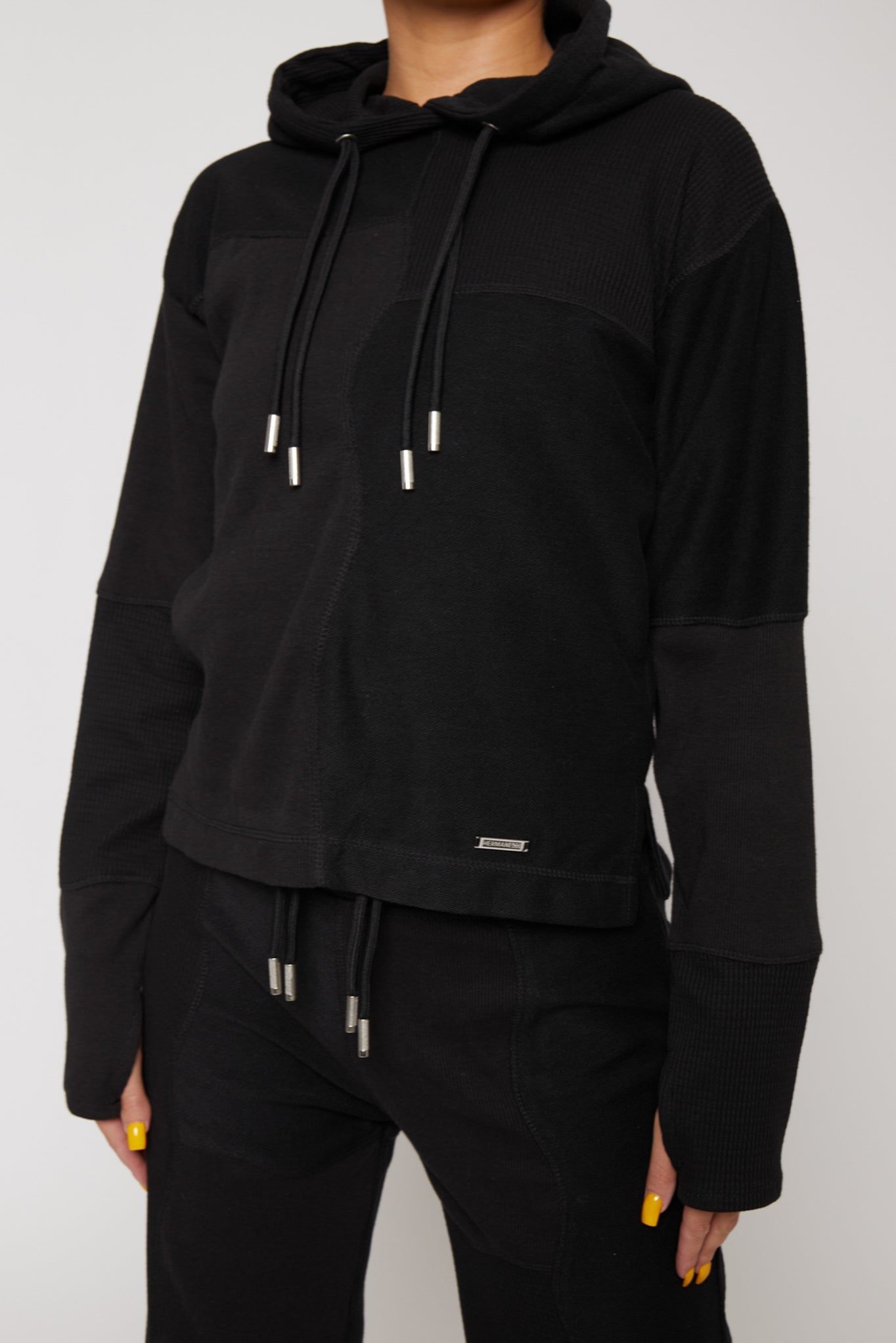 close up of metal plate detail on black hoodie hem