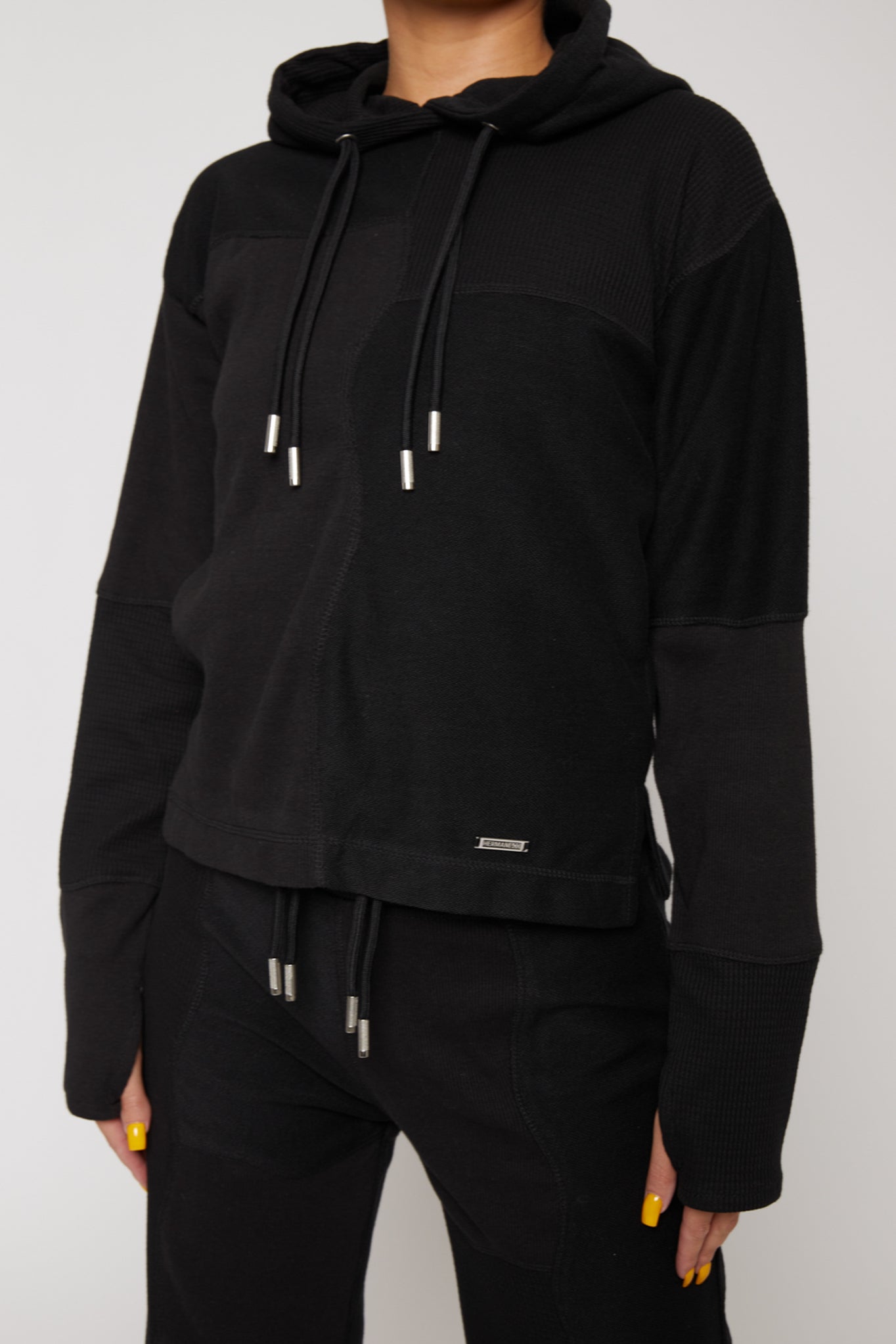 close up of metal plate detail on black hoodie hem