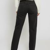 Person wearing black pants and a white top on a plain background