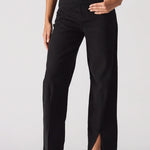 Black pants with a high slit worn by a model on a white background