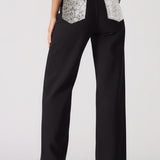 Black pants with silver pocket designs worn by a person on a white background