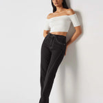 Model leaning against a wall wearing Black Popper Side Straight Jeans Women's