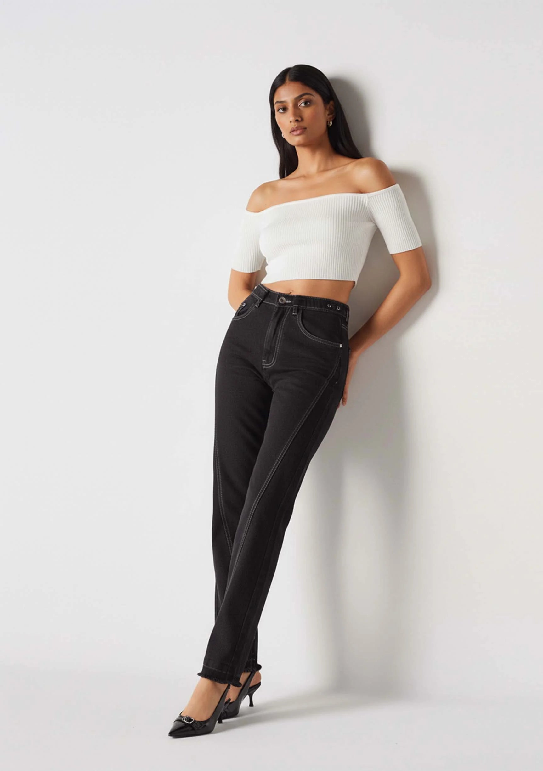 Model leaning against a wall wearing Black Popper Side Straight Jeans Women's