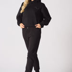 Front view of a blonde woman wearing a black pullover hoodie