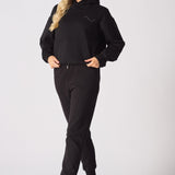 Front view of a blonde woman wearing a black pullover hoodie