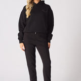 Detailed view of the tonal embroidery on a black pullover hoodie