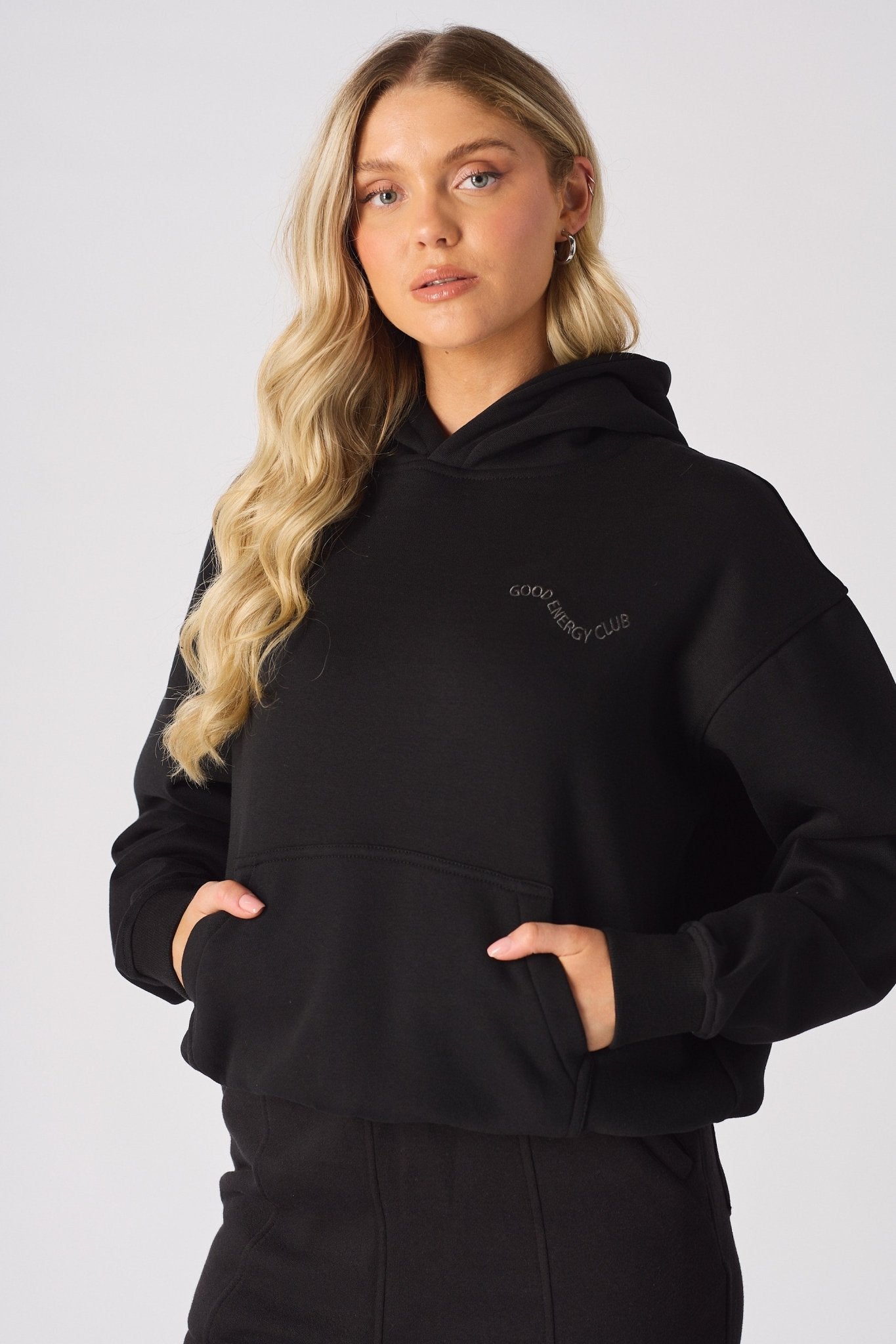 A woman wearing the hood of a soft black pullover hoodie
