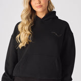 Close up of hands in the kangaroo pocket of a black pullover hoodie