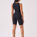 Rear view of a woman wearing a black racer neck crop top showing the athletic design