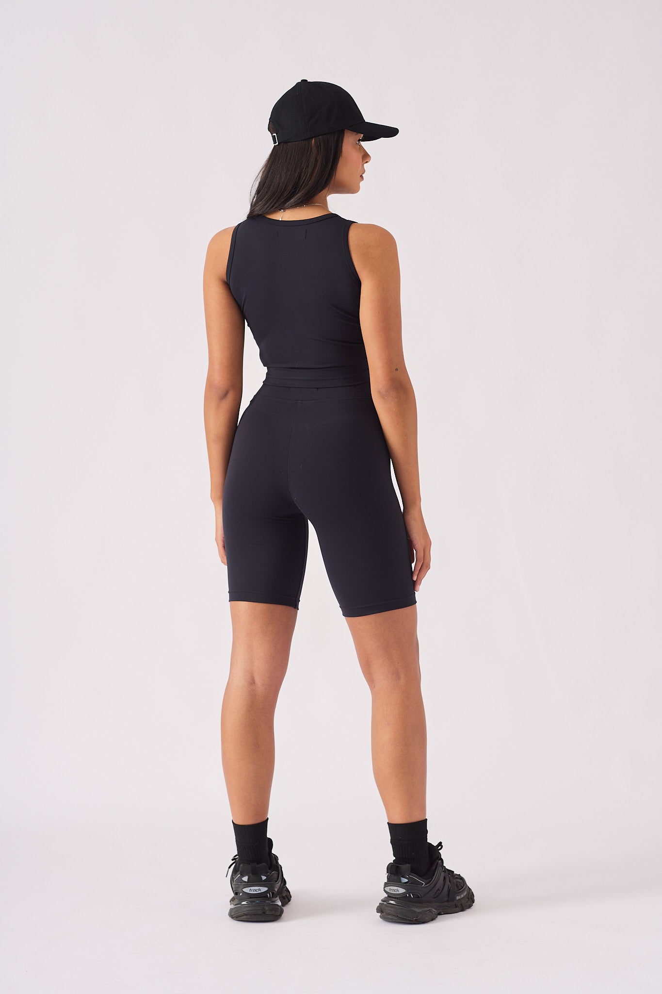 Rear view of a woman wearing a black racer neck crop top showing the athletic design