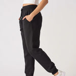 Side profile of a model posing in comfortable black relaxed fit joggers womens.