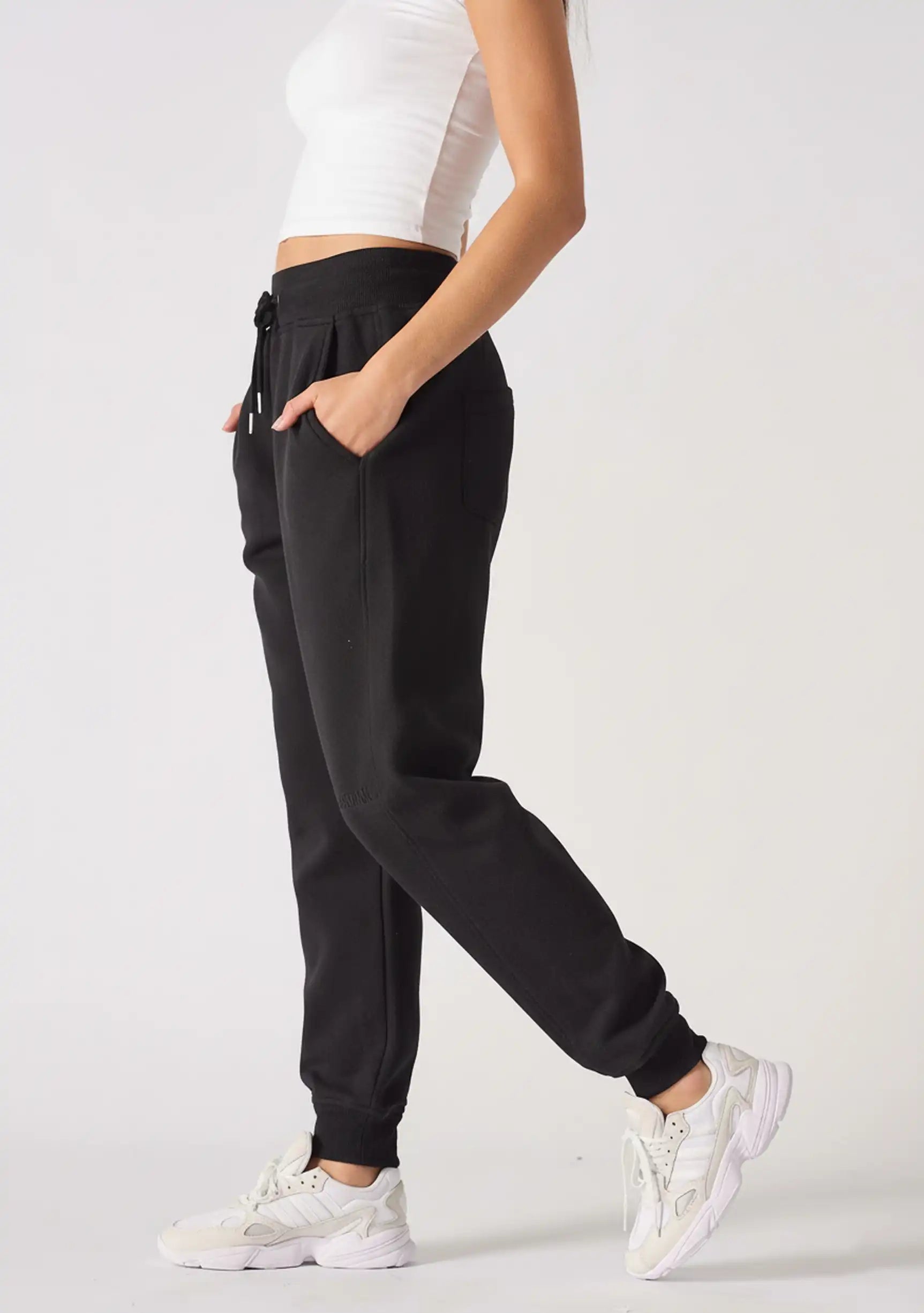 Side profile of a model posing in comfortable black relaxed fit joggers womens.