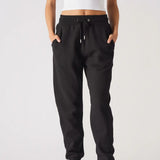 A model walking forward while wearing stylish black relaxed fit joggers womens.