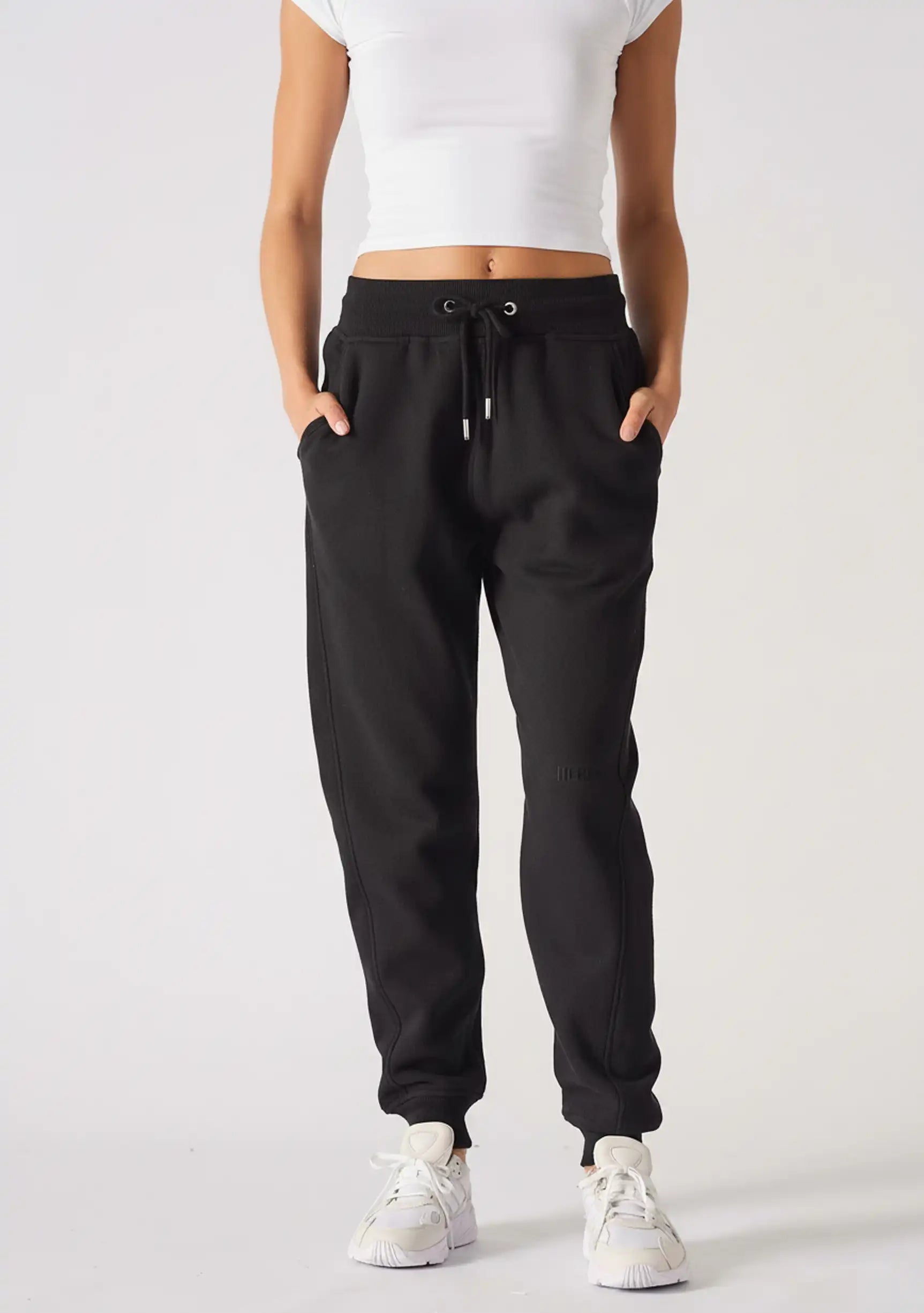 A model walking forward while wearing stylish black relaxed fit joggers womens.