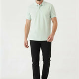 Full body view of a man styling casual black slim fit trousers with a polo shirt.