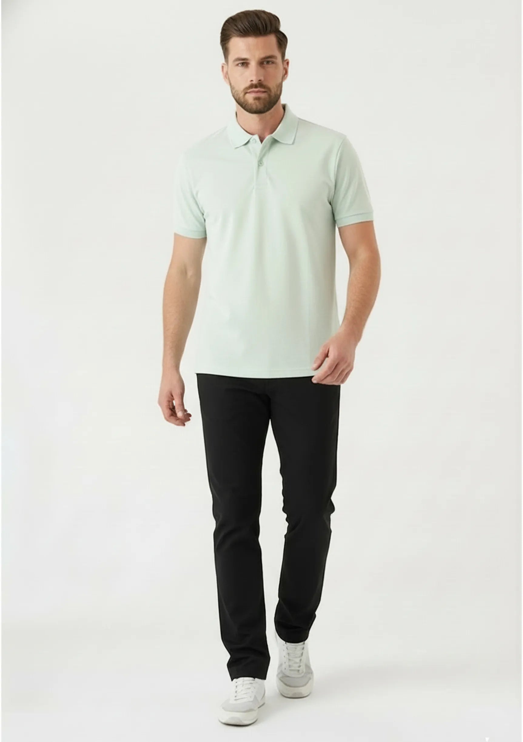 Full body view of a man styling casual black slim fit trousers with a polo shirt.