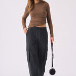 Front view of a model walking in black straight leg cargo pants women's.