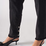 Close-up on the popper ankle detail and frayed hem of Black Wash Straight Leg Jeans